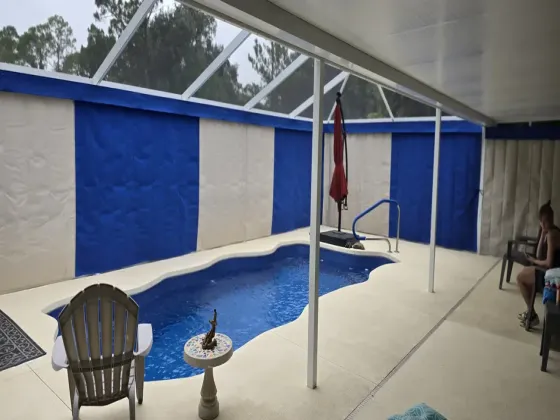 Blue and white Sunbrella privacy curtains around Florida pool enclosure