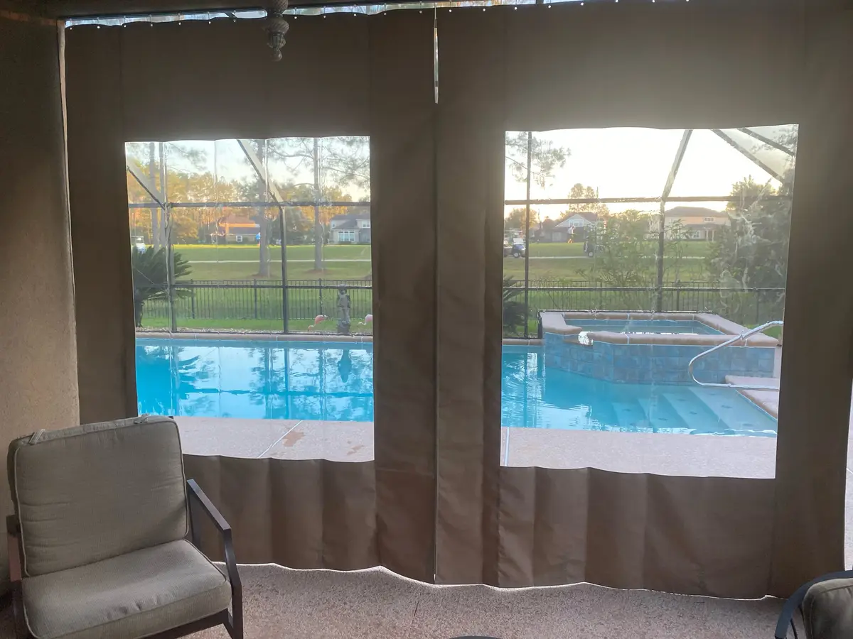 Sunbrella canvas curtains with clear vinyl windows overlooking Florida pool