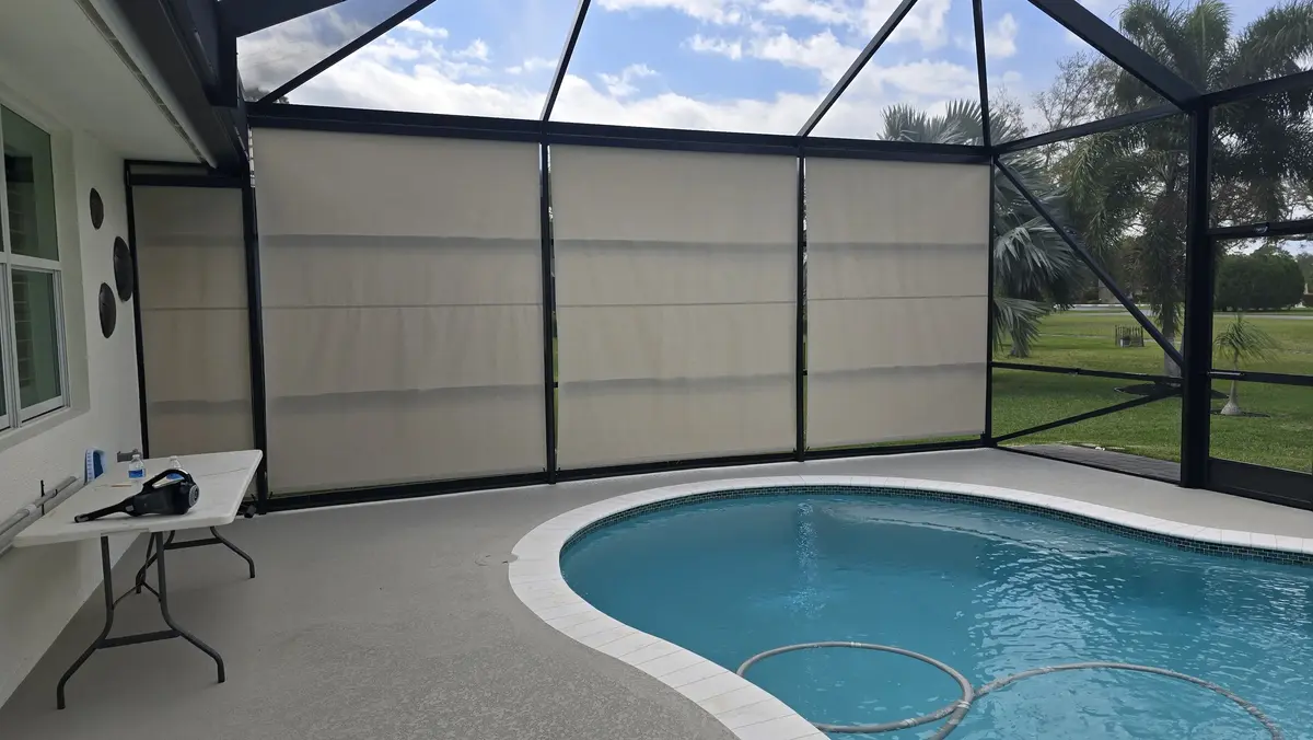 Beige UV-blocking outdoor roller shades installed in Florida pool enclosure