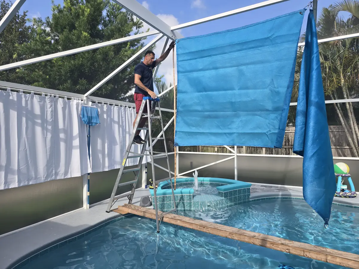 Beige HDPE shade sail panels over large Florida pool and lanai