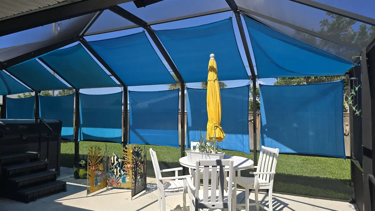 Blue HDPE mesh shade sails installed inside Florida pool cage enclosure