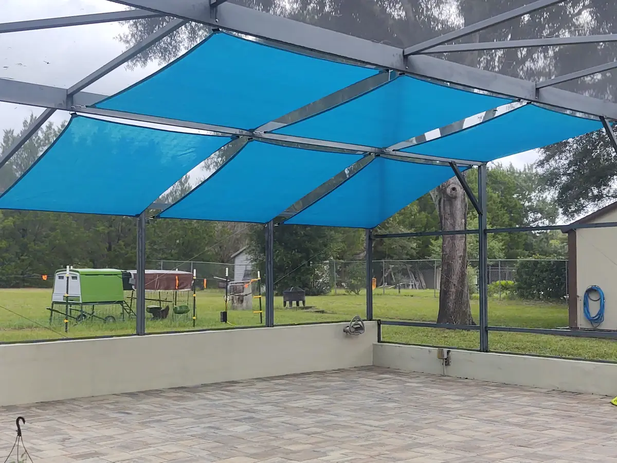 Large shade sail system covering Florida pool enclosure